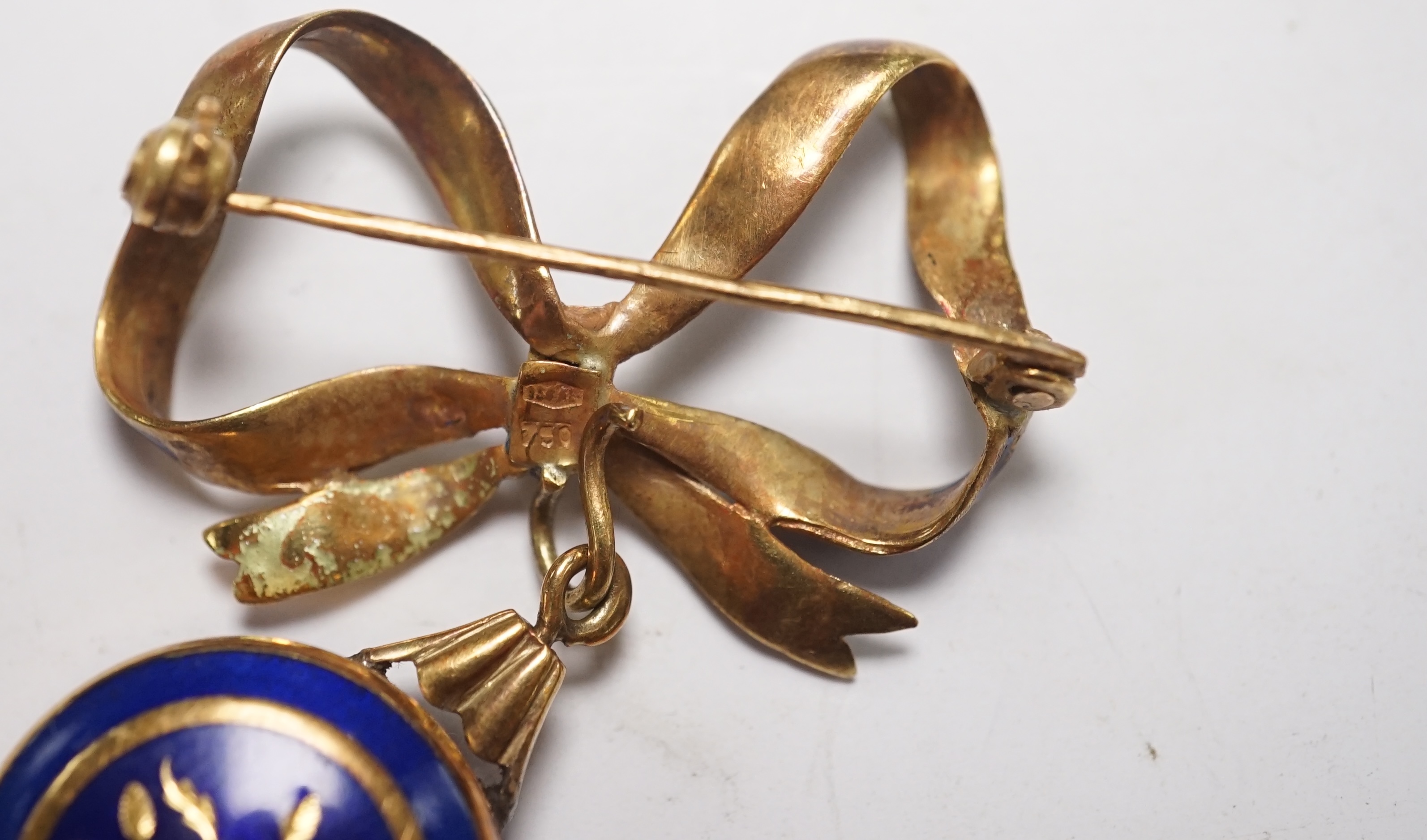 A mid 20th century Italian 750 and blue enamel fob watch, on a ribbon bow suspension brooch, overall drop 42mm, gross 10.9 grams. Condition - poor to fair